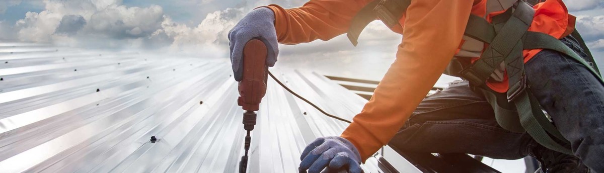 A worker is drilling the roof to inspect the house roof quality in Austin, TX A worker is drilling the roof to inspect the house roof quality in Austin, TX