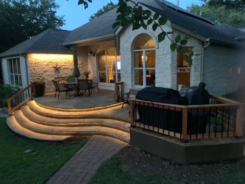 Custom patio and deck renovation service shown with lighting steps outdoor design in West Austin, TX